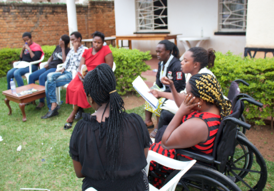The picture shows a group of young people both male and female sitting in  a  circle listening to one of them presenting to the groups on business ideals.